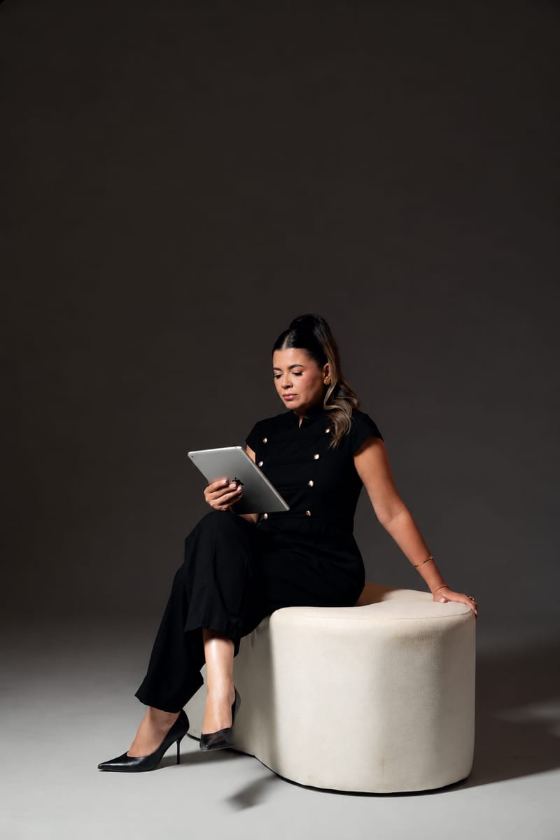 Weiri Borges sentada, consultando um tablet.